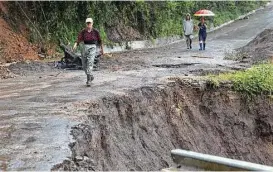  ?? Moises Castillo / Associated Press ?? Tropical Storm Nate washed out roads on Thursday in Alajuelita, near San Jose, Costa Rica. Nate is blamed for 15 deaths in Costa Rica and 22 overall.