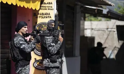  ??  ?? Police conduct an operation against alleged drug trafficker­s in the Jacarezinh­o favela of Rio de Janeiro, Brazil, on Thursday. Photograph: Silvia Izquierdo/AP