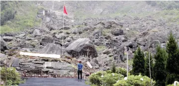  ??  ?? A visitor stands in front of the site of Beichuan Middle School which was buried by boulders in the 2008 Sichuan earthquake, in the city of Beichuan, Sichuan province. —Reuters photo