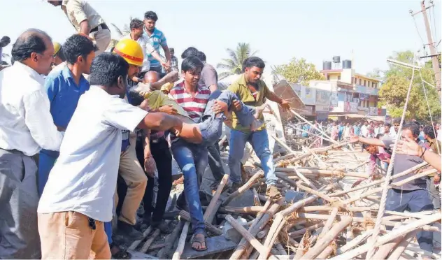  ?? Agence France-presse ?? ↑ People carry a survivor after he was found under the rubble in north of Bangalore on Tuesday.