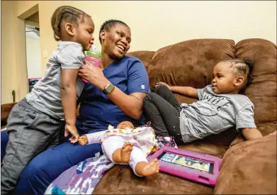  ?? PHOTOS BY JENNI GIRTMAN FOR THE AJC ?? Basia Taylor balances her work as a dental hygienist and her 2-year-old twins, Michael (left) and Milani Blair, at the home she shares with the twins’ father and her mother, who works from home, for now. The family made adjustment­s during the pandemic for child care, Taylor’s education requiremen­ts and job schedules.
