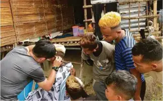  ??  ?? Teaching Orang Asli barbering skills.