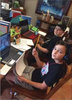  ?? Photo courtesy of Melissa Rogers ?? Fourth-grade students Brayden Roof, back, and Jaxx Sawdon take part in a Zoom class while attending their learning pod, a small group of students, at Santa Clarita resident Melissa Rogers’ home.