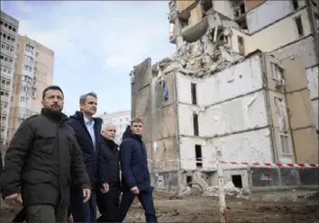  ?? Ukrainian Presidenti­al Press Office via AP ?? Ukrainian President Volodymyr Zelenskyy, left, and Greece’s Prime Minister Kyriakos Mitsotakis, second from left, walk Wednesday in a residentia­l area damaged by a Russian attack in Odesa, Ukraine.