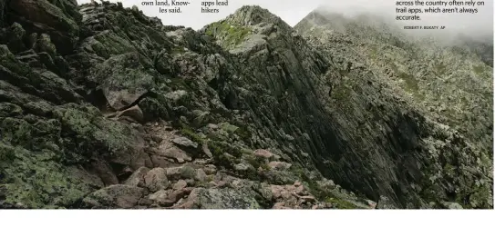  ?? ROBERT F. BUKATY AP ?? A hiker walks at cloud level on the Knife Edge, a narrow serrated ridge leading to the summit of Mount Katahdin in Maine. Wilderness enthusiast­ists across the country often rely on trail apps, which aren’t always accurate.