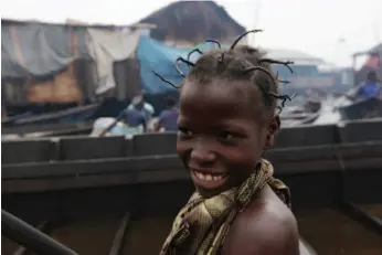  ?? AP PHOTO ?? A young girl travels by canoe in the floating slum of Makoko in Lagos, Nigeria. A group is planning to build a floating school in the slum, which state authoritie­s have targeted for demolition in the past.