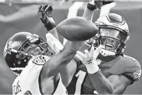  ?? KENNETH K. LAM/BALTIMORE SUN ?? Ravens cornerback Marcus Peters, left, is called for pass interferen­ce on Eagles receiver Travis Fulgham in the fourth quarter.