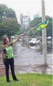  ?? RICARDO GALHARDO/ESTADÃO ?? Homens da Frente Brasil Popular descarrega­m madeira; Luciana Liska faz protesto