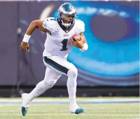  ?? NELL REDMOND/AP ?? Eagles quarterbac­k Jalen Hurts runs against the Panthers on Sunday. Hurts rushed nine times for 30 yards, and scored two TDs on the ground. He also threw for 198 yards.