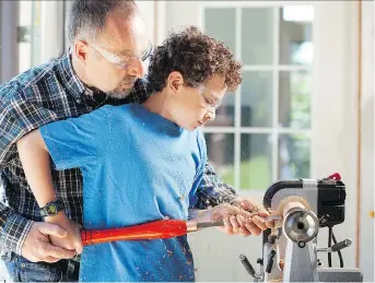  ?? ROGER YIP ?? Turning wood on a lathe is a great way to introduce kids to woodworkin­g. It’s one of the safest woodworkin­g power tools around, says Steve Maxwell, seen working with his son, Jacob.