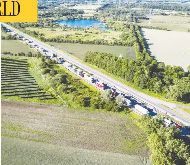  ?? RITZAU SCANPIX / VIA REUTERS ?? Vehicles queue on highway E45 in Froeslev, Denmark, after the country opened its borders to Germany on Monday.