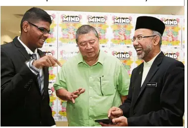  ??  ?? Way too fast: Yaashwin beating the calculator again as Ling and SMK Bandar Tun Hussein Onn 2 principal Ahmad Ezzat Ismail (right) try to work out a math problem.