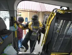  ?? Darrell Sapp/Post-Gazette ?? Left: Kevin Cotton with his pets Louie and Cammie and his VETaxi. Right: Mr. Cotton helps Cuyler Mikell, of Mt. Lebanon, into his VETaxi after a physical therapy session in Bethel Park. Mr. Cuyler served 21 years in the Navy.