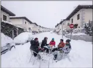  ??  ?? Neighbors gather in the middle of a street Saturday amid heavy snowfall in Bustarviej­o, Spain. More photos at arkansason­line. com/110filomen­a/. (AP/Bernat Armangue)