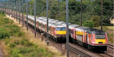  ?? PETER FOSTER. ?? On August 24, a Virgin Trains East Coast High Speed Train led by 43313 passes a Class 91/Mk 4 set trailed by Driving Van Trailer 82210 at Marholm (near Peterborou­gh). Virgin is reporting a 33% share of the air/rail market on the UK’s busiest domestic...