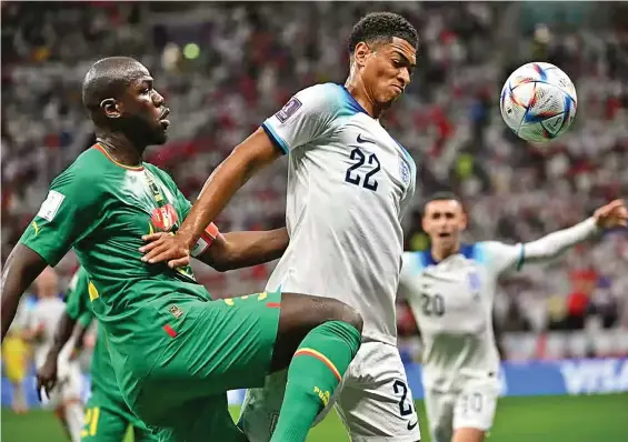  ?? Photo: London Evening Standard. ?? England midfielder Jude Bellingham (22) controls the ball as he is challenged by Senegal defender Kalidou Koulobal during their FIFA World Cup Last16 clash at Al Bayt Stadium in Qatar on December 4, 2022. England won 3-0 and faces France in the quarterfin­al.