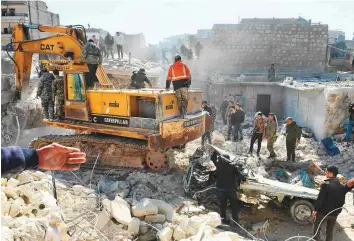  ?? AFP ?? ■ People watch as rescuers sift through the rubble of a building that collapsed in the northern Syrian city of Aleppo yesterday. Reports said five children were among the dead.