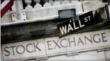  ?? MARK LENNIHAN — THE ASSOCIATED PRESS FILE ?? This file photo, shows a Wall Street street sign outside the New York Stock Exchange. U.S. stock indexes ticked higher in early trading on Tuesday and tacked on a bit more to their records set a day earlier.