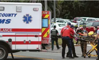  ?? Tori Schneider / Associated Press ?? A person is transporte­d from the scene of a shooting Friday at a yoga studio in Tallahasse­e, Fla. Two women were killed and five other people were wounded in the shooting.