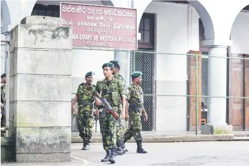  ?? — AFP photo ?? Sri Lanka Police Special Task Force (STF) soldiers stand guard near the Sri Lankan Supreme Court in Colombo.