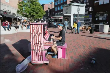  ?? STEVEN SENNE/AP PHOTO ?? Scott Frazer of Medford, Mass., plays a piano on the sidewalk in the Harvard Square area of Cambridge, Mass.