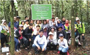  ??  ?? Participan­ts of the tree planting programme pose for a group photo in the Sampadi Forest Reserve.