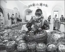  ?? KIRILL KUDRYAVTSE­V / AFP ?? A volunteer inspects traditiona­l cakes and eggs to be distribute­d to people in need in Moscow on the eve of the Orthodox Easter.