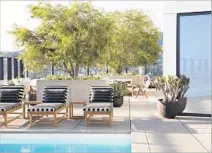  ??  ?? THE ROOFTOP LOUNGE above features (from left) ICW Emmett Chairs, KW Terra Firma Outdoor Fabric chairs and Niche Beverly Love Seat. At top right is a one-bedroom unit with Time Mapping art from Emily Snyder. The rooftop pool is seen above.