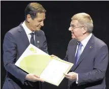  ?? LEO CORREA / ASSOCIATED PRESS FILE ?? Russian Olympic Committee head Alexander Zhukov (left) receives the official invitation for the 2016 Olympic games from the IOC President Thomas Bach.