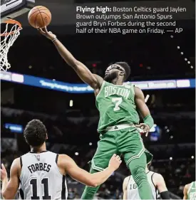  ?? — AP ?? Flying high: Boston Celtics guard Jaylen Brown outjumps San Antonio Spurs guard Bryn Forbes during the second half of their NBA game on Friday.