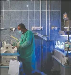  ??  ?? A doctor checks a malnourish­ed newborn baby June 27 inside an incubator at Al-Sabeen hospital in Sanaa, Yemen. Coronaviru­s restrictio­ns on movement have blocked the distributi­on of aid, along with the stalling of salaries and price hikes.
(AP/Hani Mohammed)