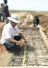  ??  ?? Chen Zongquan checks on the quality of steel reinforcem­ents in an irrigation canal