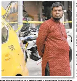  ??  ?? Food deliverers clean up a bicycle after a cab plowed into the front of Westville restaurant. Driver M.D. Shuliaman said he lost control of his car after he was rear-ended by another motorist, causing him to jump the curb.