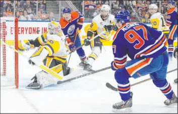  ?? Jason Franson The Associated Press ?? Penguins goalie Alex Nedeljkovi­c stops a shot by Oilers center Connor Mcdavid in Edmonton’s 6-1 victory Sunday at Rogers Place. Mcdavid had a goal and an assist.