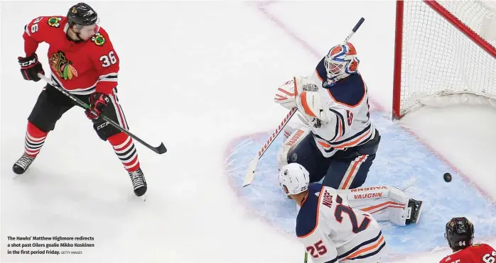  ?? GETTY IMAGES ?? The Hawks’ Matthew Highmore redirects a shot past Oilers goalie Mikko Koskinen in the first period Friday.