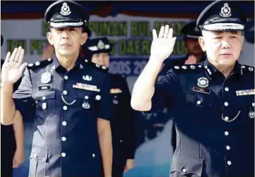  ??  ?? AH Lek (kanan) mengetuai bacaan ikrar ketika menghadiri Perhimpuna­n Bulanan Ketua Polis Daerah Kuching Siri 3/2018, di Padang Kawad, Ibu Pejabat Polis Daerah Kuching.