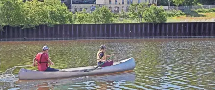  ?? MICHAEL SEARS / MILWAUKEE JOURNAL SENTINEL ?? Todd Engen, left, and Jennifer Ward paddle a canoe borrowed from the Urban Ecology Center on the Milwaukee River in 2018.