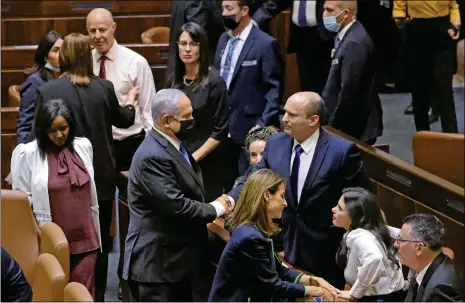  ?? Photo: VCG ?? Israel’s outgoing prime minister Benjamin Netanyahu ( middle left) shakes hands with his successor Naftali Bennett, after a special session to vote on a new government at the Knesset in Jerusalem on Sunday.