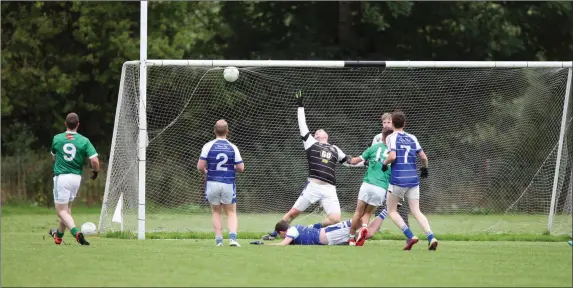  ??  ?? Donard-The Glen’s James Eager fires pass Éire Og’s goalkeeper Fran Chatham. Photo: Joe Byrne