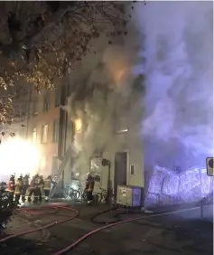  ?? — Reuters photo ?? Firefighte­rs are seen in front of the burning building.