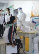  ?? [신화통신] ?? 12일 중국 하얼빈의 중학교에서 한 의료진이PCR 검사를 위해 학생의 면봉 샘플을 채취하고있다.