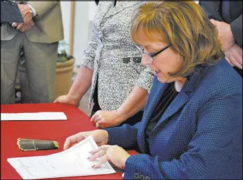 ?? RUSSELL CONTRERAS/THE ASSOCIATED PRESS ?? New Mexico Gov. Susana Martinez signs a state REAL ID bill March 8 at Sunport Internatio­nal Airport in Albuquerqu­e, N.M. The number of immigrants seeking driver’s licenses in New Mexico has slowed but remains on pace to reach a four-year high.