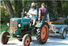  ??  ?? Hermann Habersetze­r fuhr die Sautröge mit seinem Oldtimer-Traktor wieder zum Startplatz.