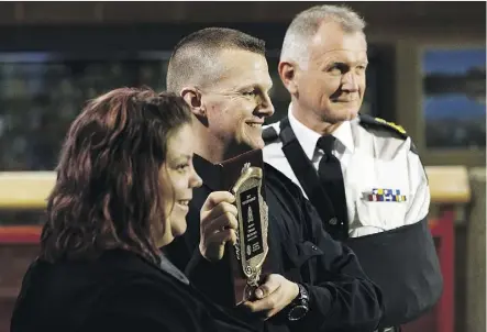  ?? IAN KUCERAK ?? Heather Gillis, left, past president of the Kiwanis Club of Edmonton and EPS chief Rod Knecht, right, flank Kiwanis 2017 Top Cop Award winner Const. Michael Zacharuk during a ceremony on Friday.