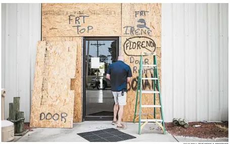  ?? JULIA WALL/THE NEWS & OBSERVER ?? Terry Crabtree boards up the entrance to Downeast Marine in Otway, N.C., as Isaias threatens the Carolinas on Monday.
