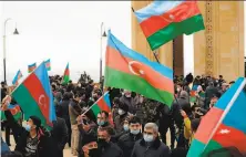  ?? Tofik Babayev / AFP via Getty Images ?? People in the Azerbaijan capital of Baku celebrate Armenia’s transfer of the warravaged ghost town of Aghdam.