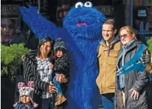  ?? (AFP photos) ?? A person dressed as the ‘Sesame Street’ character Cookie Monster poses for a photo with tourists on 42nd Street