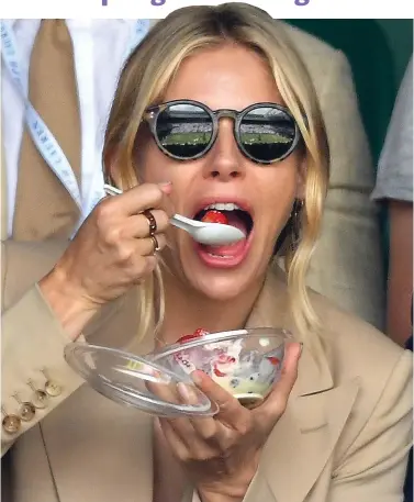  ?? ?? Fan: Actress Sienna Miller samples the traditiona­l Wimbledon treat