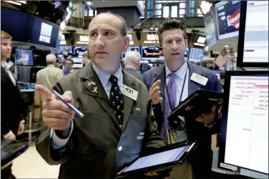  ?? AP/RICHARD DREW ?? Traders Andrew Silverman (left) and Glenn Kessler work Wednesday on the floor of the New York Stock Exchange. Most U.S. stocks fell Wednesday as investors assessed the Federal Reserve’s latest policy decision for the timing of interest-rate increases.