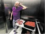  ?? Gary Coronado / Houston Chronicle ?? Andrew Cloud, props associate, rides the elevator with a tub of mock human flesh made from instant potatoes.